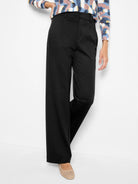 Black, drapey wide-leg trousers. High-waisted, smooth front, with subtle fabric texture.