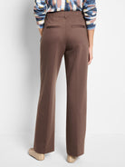 Dark brown wide-leg trousers with a drapey look, featuring back welt pockets and belt loops.