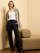 Black drapey wide-leg trousers worn by a model. High-waisted with front pleats and side pockets.