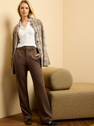 Dark brown drapey wide-leg ponte trousers, high-waisted with tailored front pleats, worn by a standing model.