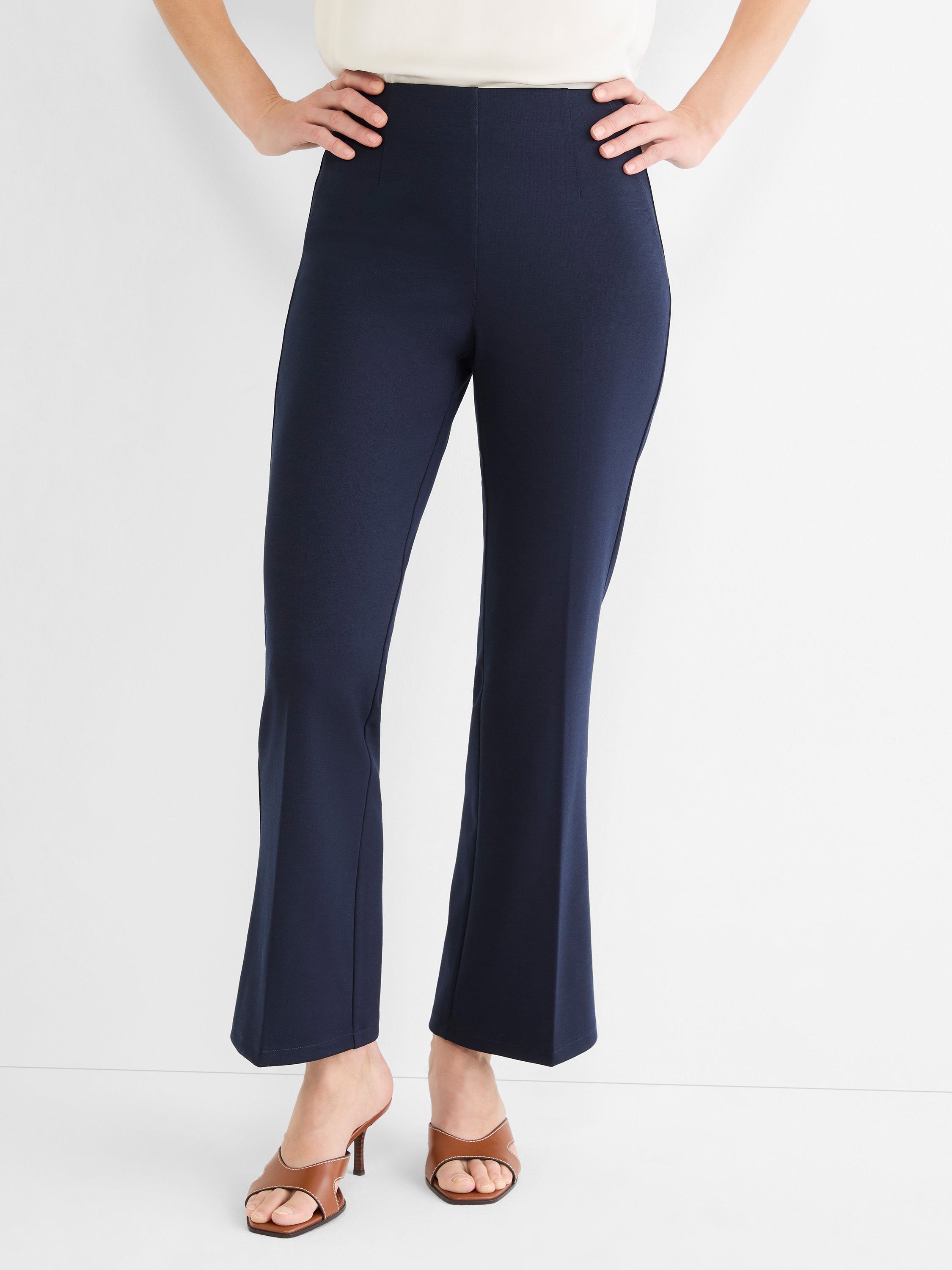 Navy blue high-waisted pull-on pants feature a slim fit through the leg and a modern cropped kick-flare hem.