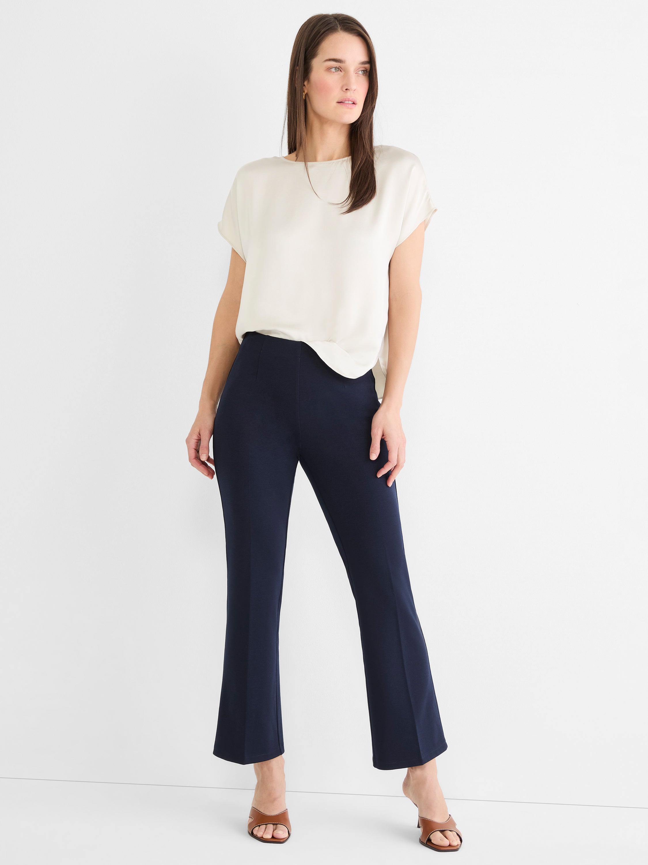 Dark blue high-waisted cropped pants feature a slim fit through the thigh and a subtle flare at the ankle.