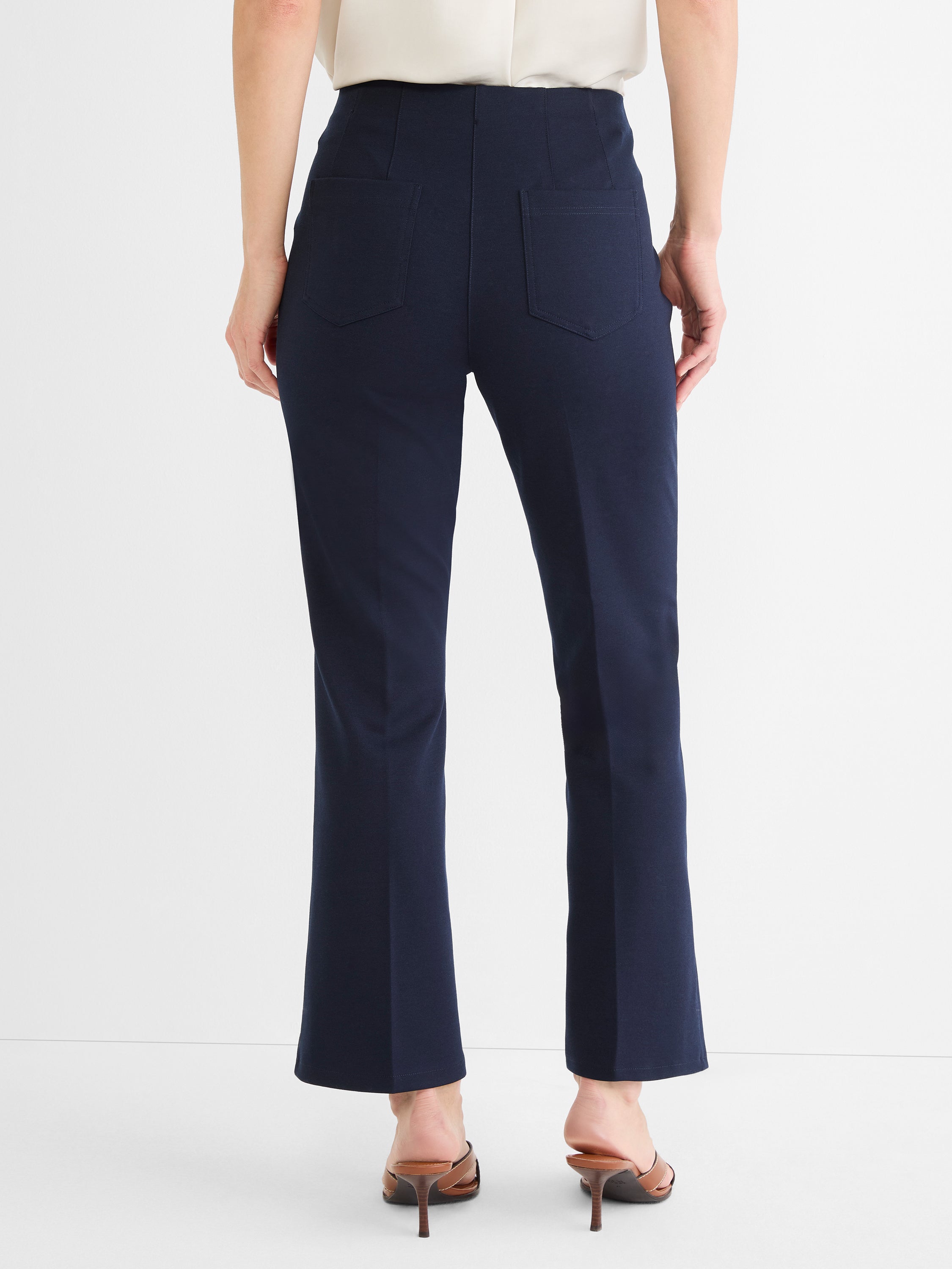 Navy high-waist cropped pants with a slight flare and two prominent rear patch pockets are shown.