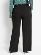 Back view of black wide leg pants. Smooth, sleek fabric with visible vertical back creases.
