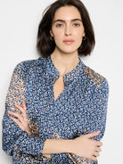 Navy, light blue, white, & orange abstract monogram top. Features standing collar, V-neck, long sleeves.