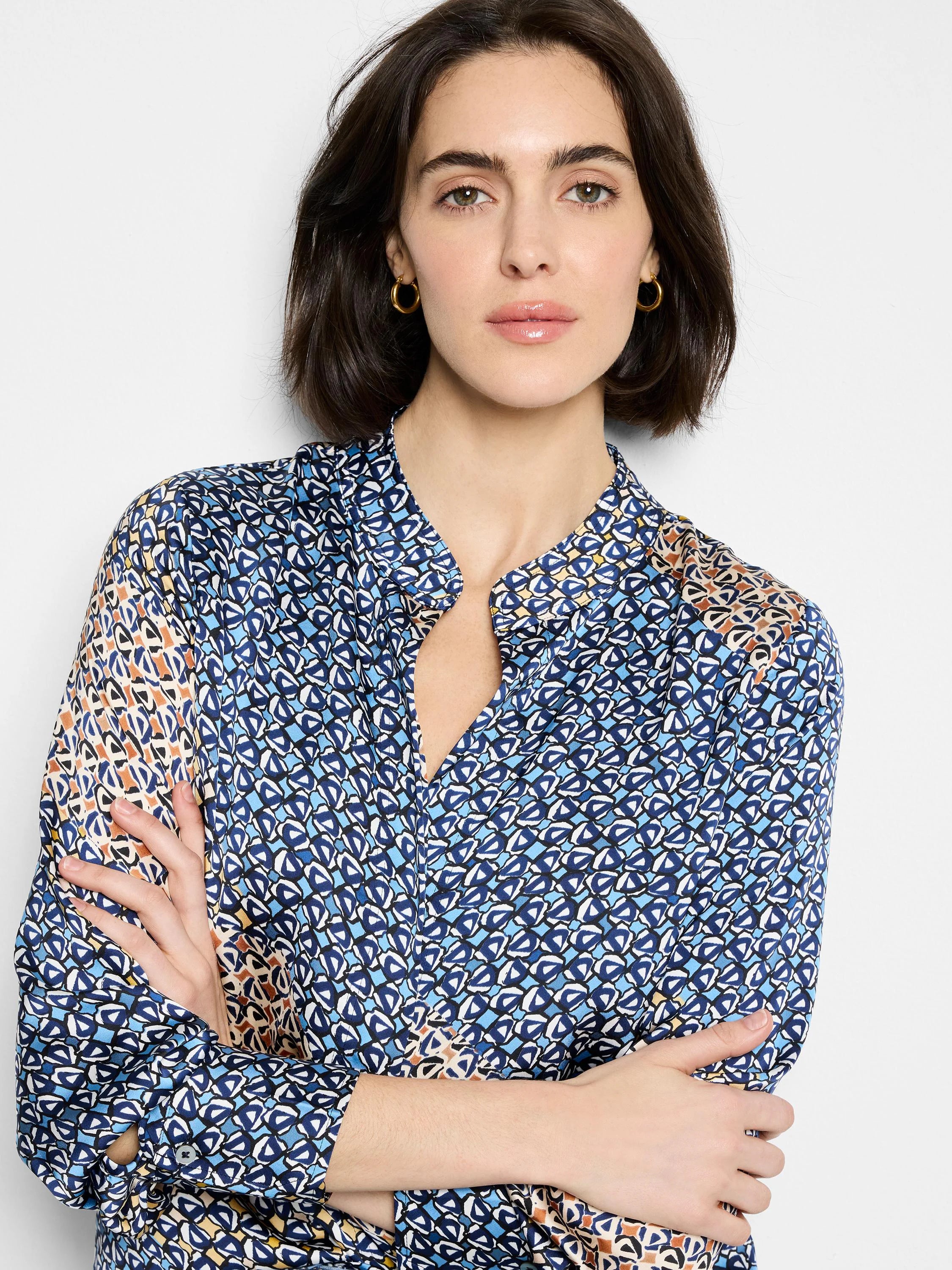 Navy, light blue, white, & orange abstract monogram top. Features standing collar, V-neck, long sleeves.