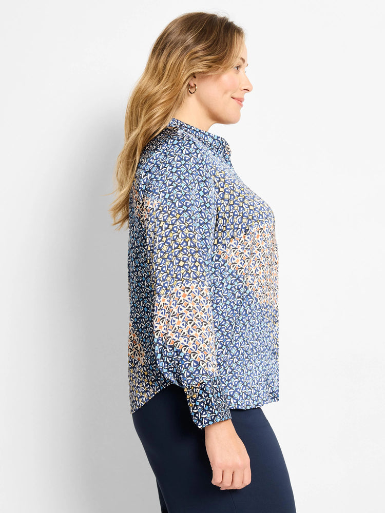Collared long-sleeve top with a mixed monogram pattern in shades of blue, cream, and orange. Button cuffs.