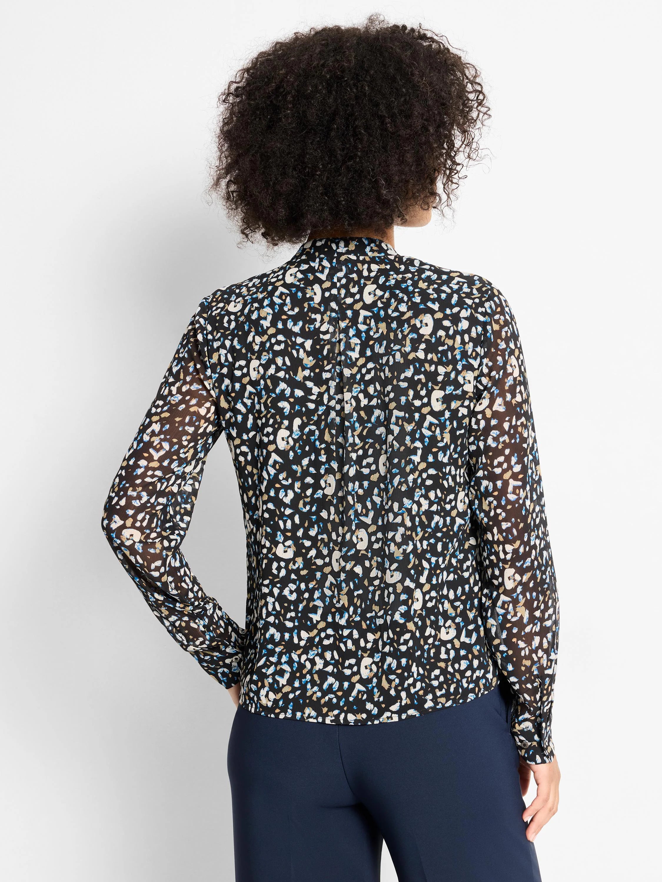 Black sheer long-sleeve top with white, blue, and tan cheetah spots, stand collar, shown tucked.