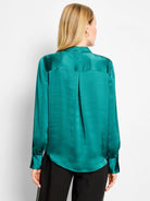 Emerald green glossy shirt, back view. Features a shoulder yoke, central back pleat, and wide cuffs.