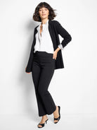 White collared shirt layered under a black, long-sleeved open button-down shirt.