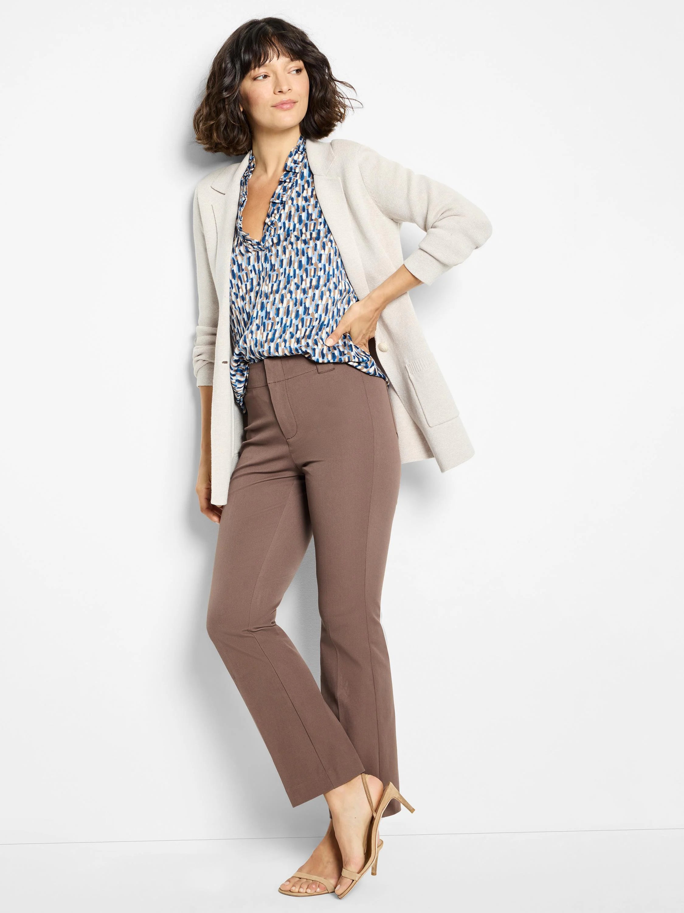 Off-white cardigan, blue and beige patterned blouse with ruffled neckline, brown straight-leg pants.