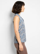 Sleeveless top, blue, beige, and white brushstroke pattern. Ruffled neckline.