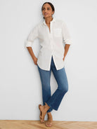 White ruffle trim button-front shirt with a chest pocket and rolled-up sleeves.