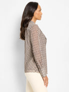 Beige and dark brown abstract falling dot pattern chiffon top with long sleeves, shown on a model.