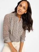 Brown & beige chiffon top with elongated scale pattern, a partial button front, and long sleeves with gathered cuffs.