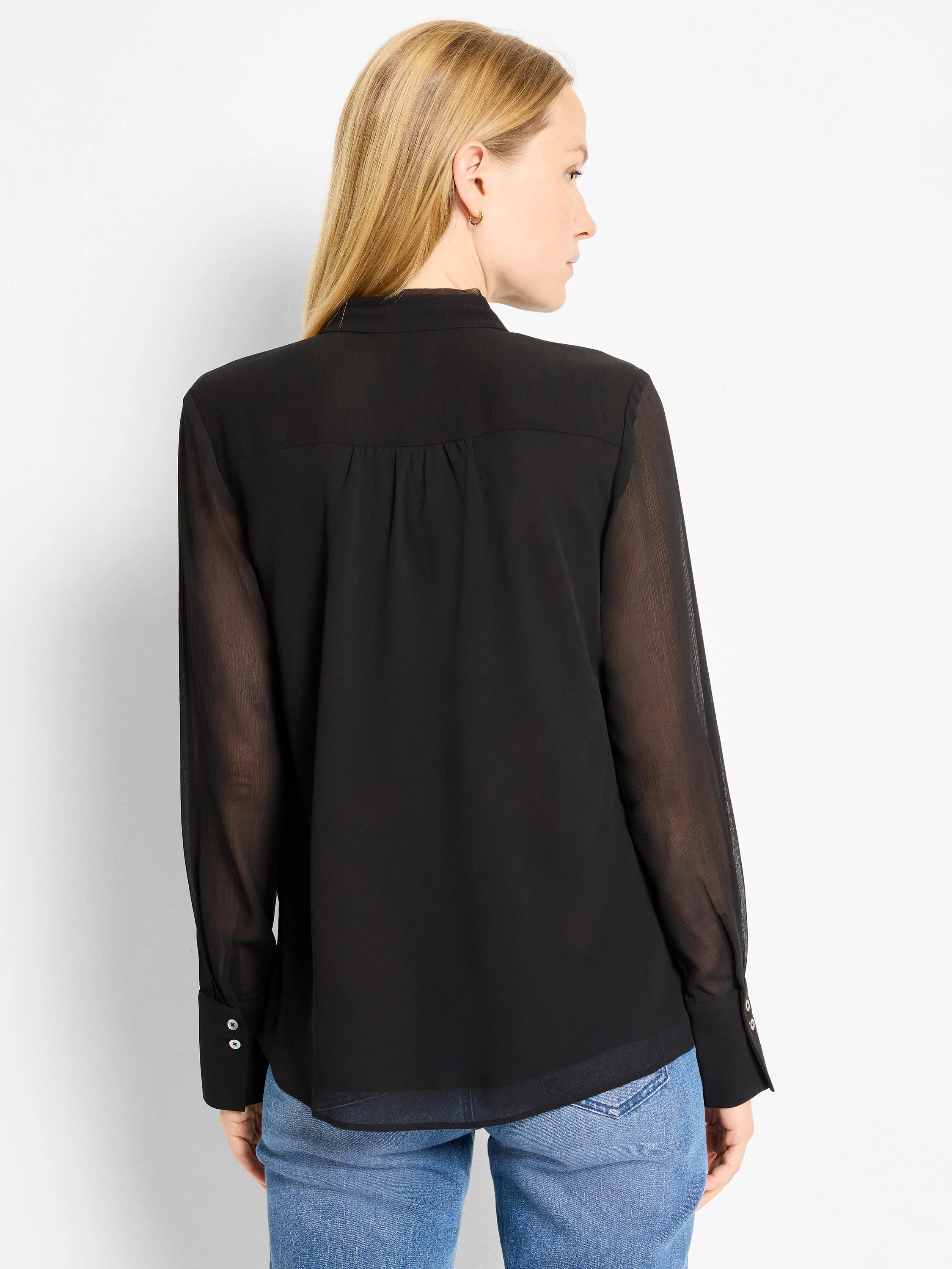 Black chiffon top with opaque body, sheer long sleeves, stand collar, pleated back, and two-button cuffs.