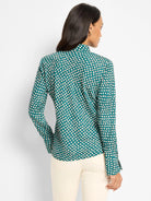 Teal long-sleeved top with cream dots, each outlined in dark brown/black. Model shown from the back.