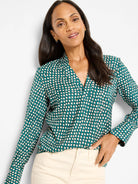 Dark teal long-sleeve blouse with V-neck, featuring small, light cream shadow dots.