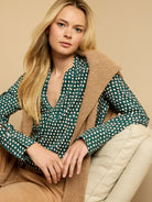 Dark green long-sleeve top with a V-neck, featuring irregular white dots with a subtle dark shadow effect.