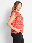 Red cap sleeve top with a white and black squiggle check pattern.