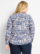 Long-sleeve blouse with abstract dot pattern in dark blue, light blue, beige, white, and black. Features collar & back pleat.
