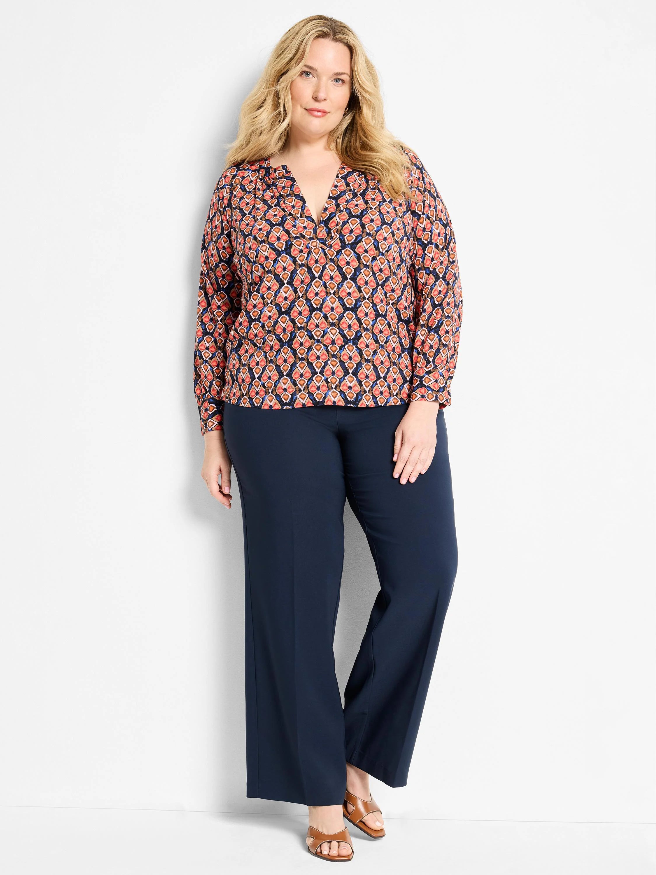 Long-sleeve V-neck top with an ikat pattern in navy, terracotta, and peach.