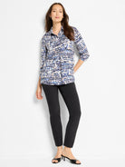 Black slim-fit pants shown on a model.  The model also wears a patterned shirt with blue, beige, and white abstract print.
