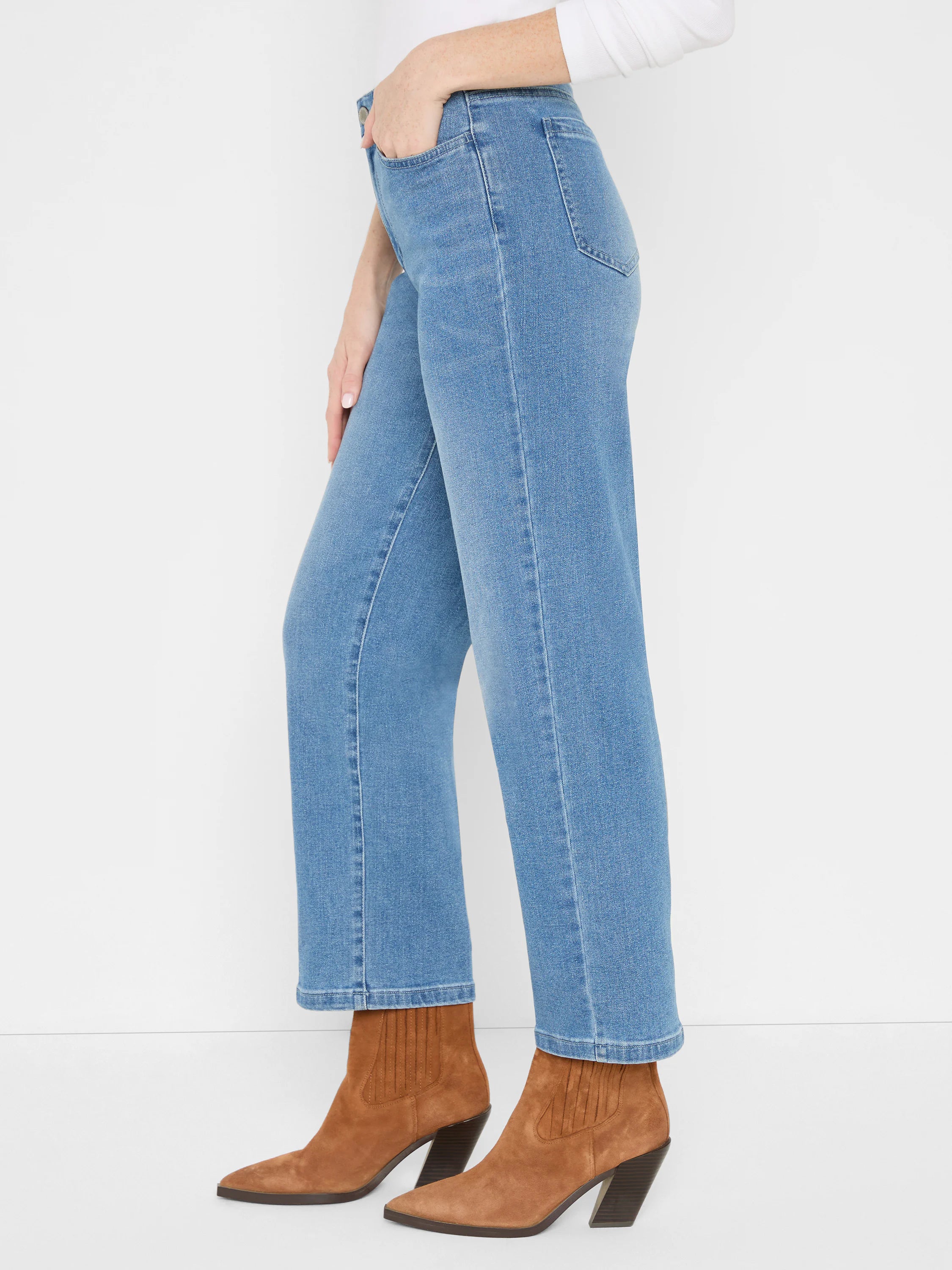 Medium blue straight ankle jeans, high-waisted, worn with brown boots.