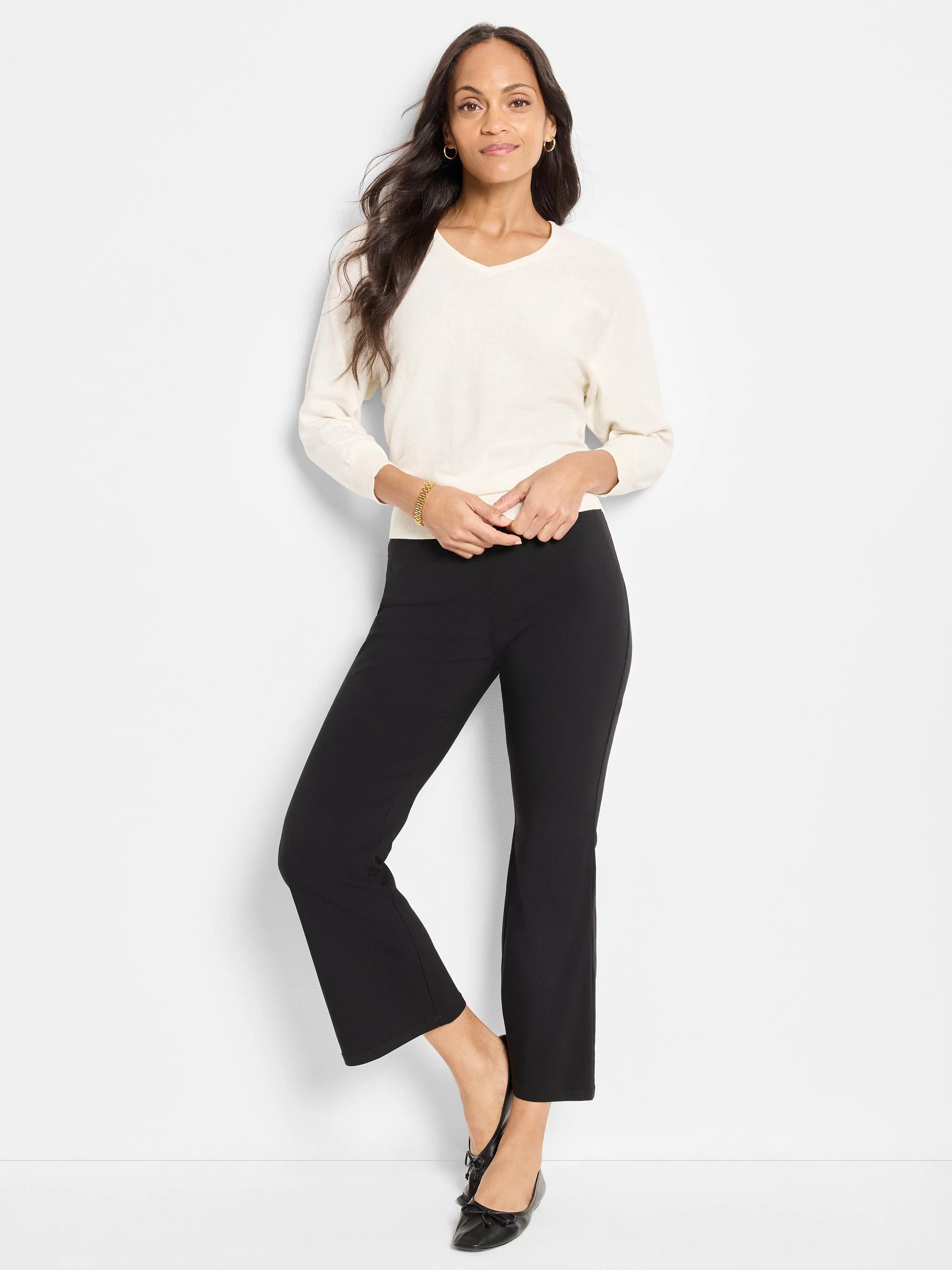 Black bootcut pants, fitted through the leg, gently flaring to a cropped ankle length.