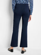 Navy blue bootcut pants, high-waisted with two back patch pockets, shown from rear. Hem ends above ankle.