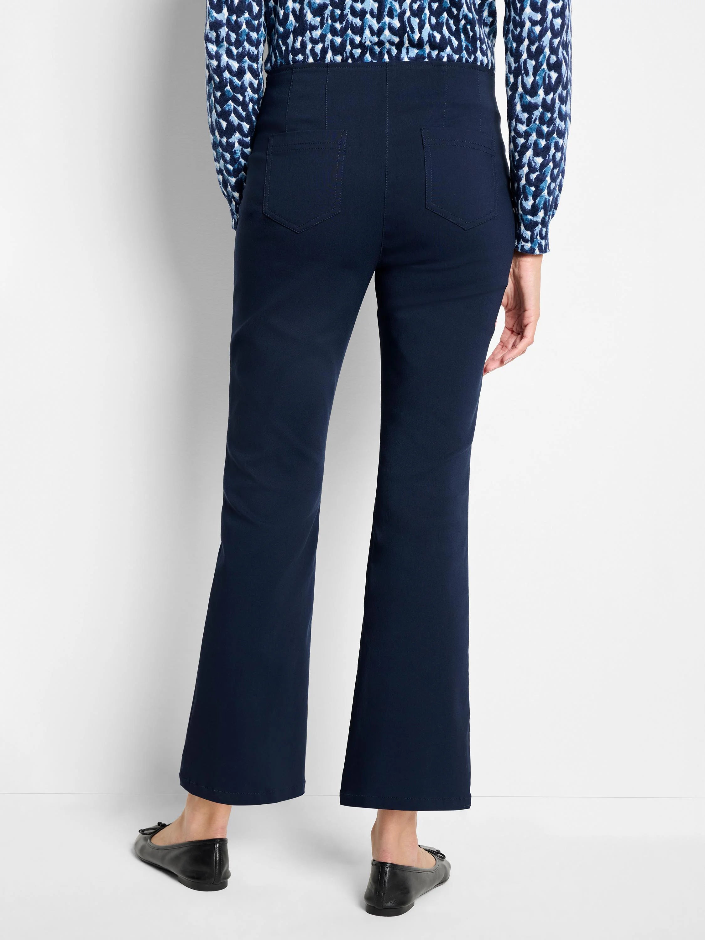 Navy blue bootcut pants, high-waisted with two back patch pockets, shown from rear. Hem ends above ankle.