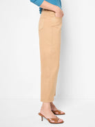 Side view of light tan barrel leg jeans. Features a relaxed fit, visible pockets, and cropped length.