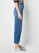 Medium blue wash, high-waisted barrel leg jeans with cropped ankles.
