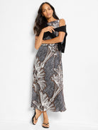 Black midi dress with white and brown palm-leaf print. Boat neck, sleeveless.