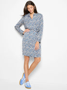 Long-sleeved knee-length dress; blue, beige, and white abstract print.  Wrap style with a collared neckline.
