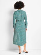 Dark green midi dress with light shadow dots, long sleeves, and a tied waist.