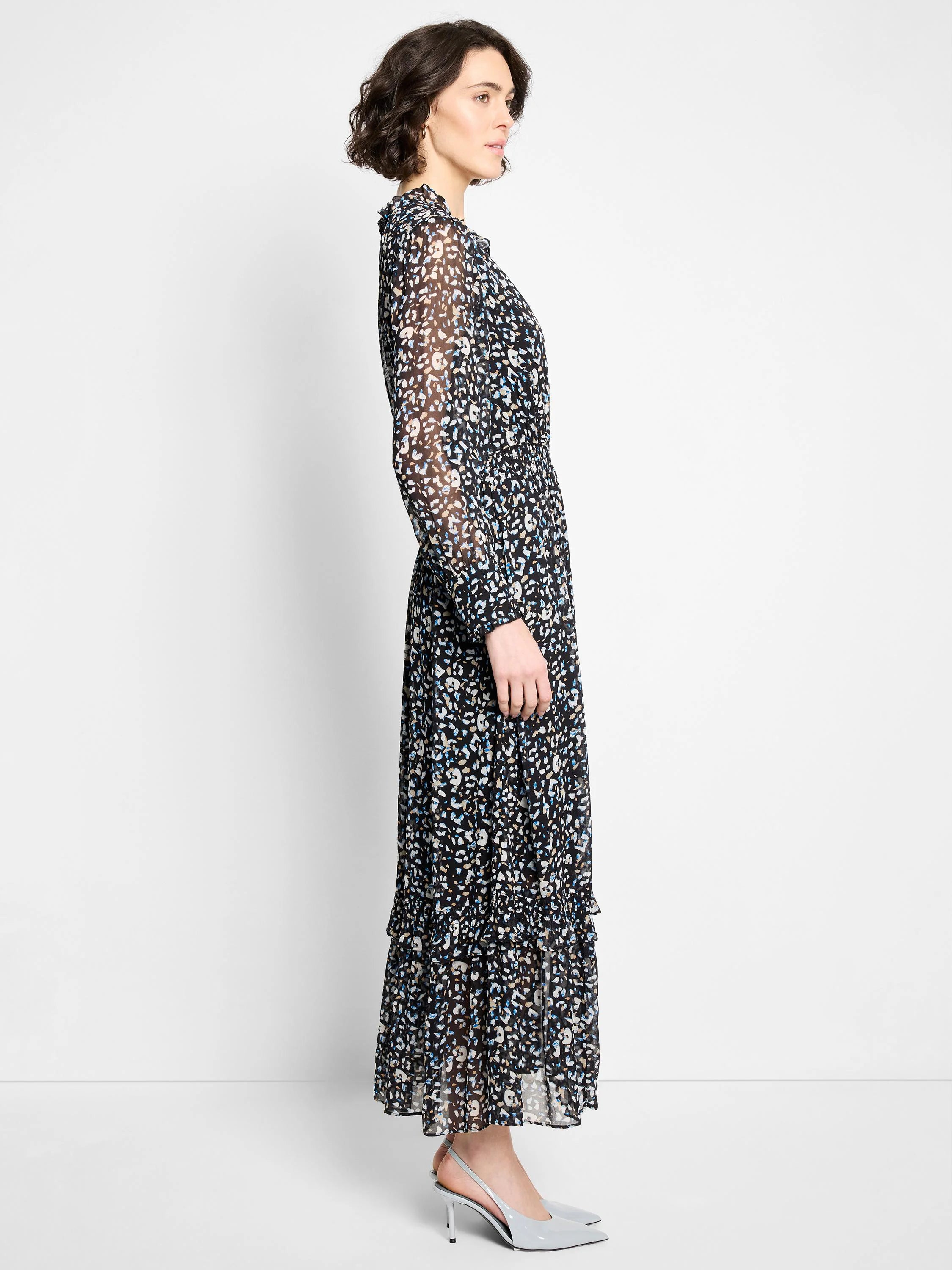 Black maxi dress with sheer long sleeves, ruffled neck, and abstract blue, tan, white pattern. Tiered skirt, elastic waist.