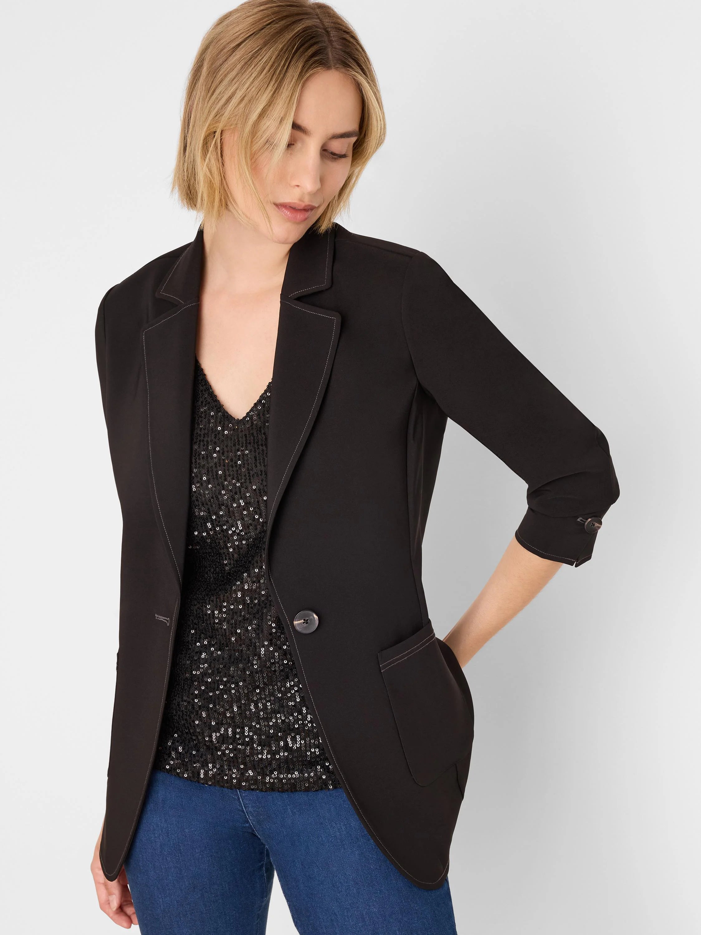 Black blazer with light accent stitching on lapels, pockets, and cuffed sleeves. Single front button closure.