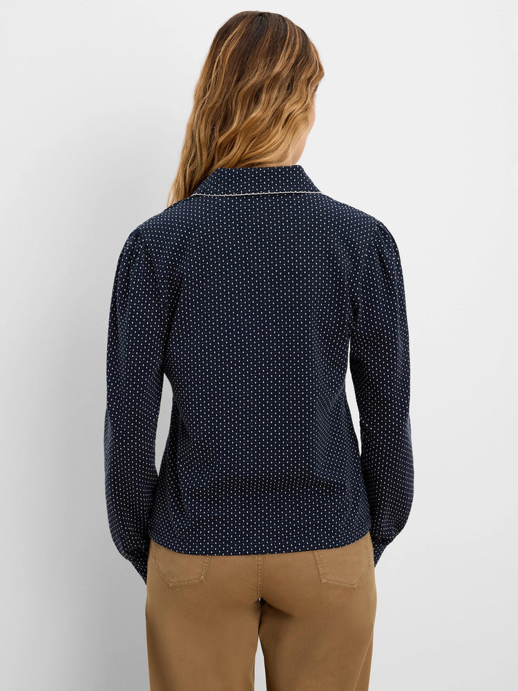 Navy blue long-sleeved top with small white dots and a collar featuring light trim.