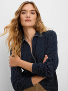 Navy polo top with white polka dots. White contrast trim on collar and button placket. Dark buttons.