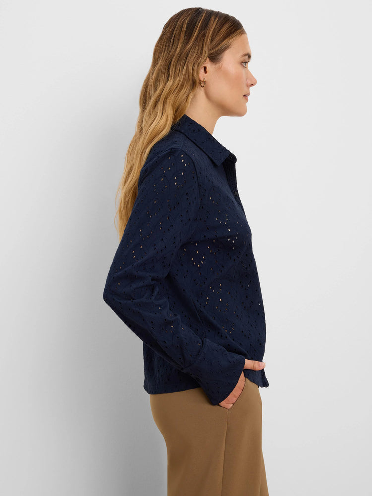 Navy knit eyelet top with long sleeves and a collar, featuring a delicate, leaf-like cut-out pattern.