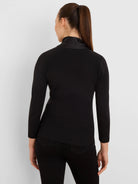 Black ribbed long-sleeve top with a high, smooth mock-neck collar, seen from behind.