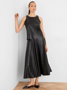 Black vegan leather sleeveless top with a round neck and a tiered hem.