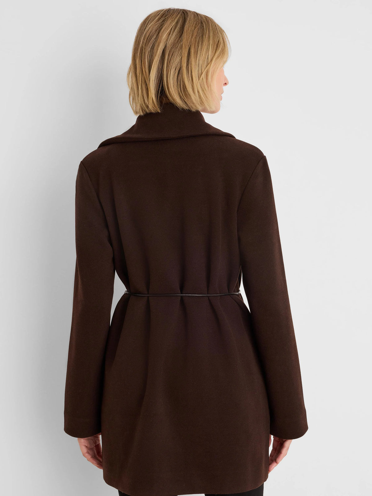 Dark brown wrap jacket, back view. Long sleeves; thin black belt cinches the waist, creating subtle folds.