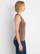 Brown ribbed knit scoop neck tank worn by a model, shown in profile.