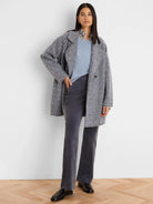 Mixed grey boucle knit jacket with a salt-and-pepper texture, lapels, and a relaxed, mid-thigh length.