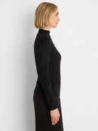 Fitted black sparkly long-sleeve mock neck top, shown from the side.