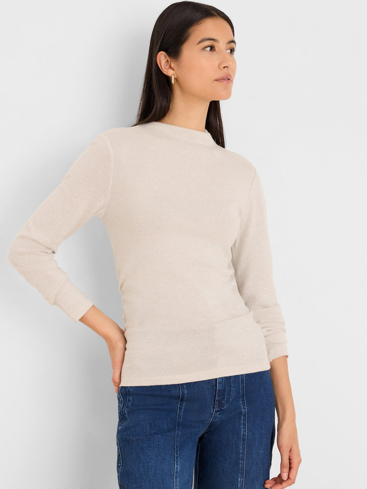 Shimmering light beige ruched mock neck top with long sleeves. Fitted silhouette.