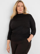 Black sparkle top with a high neck, 3/4 sleeves, and ruched sides.