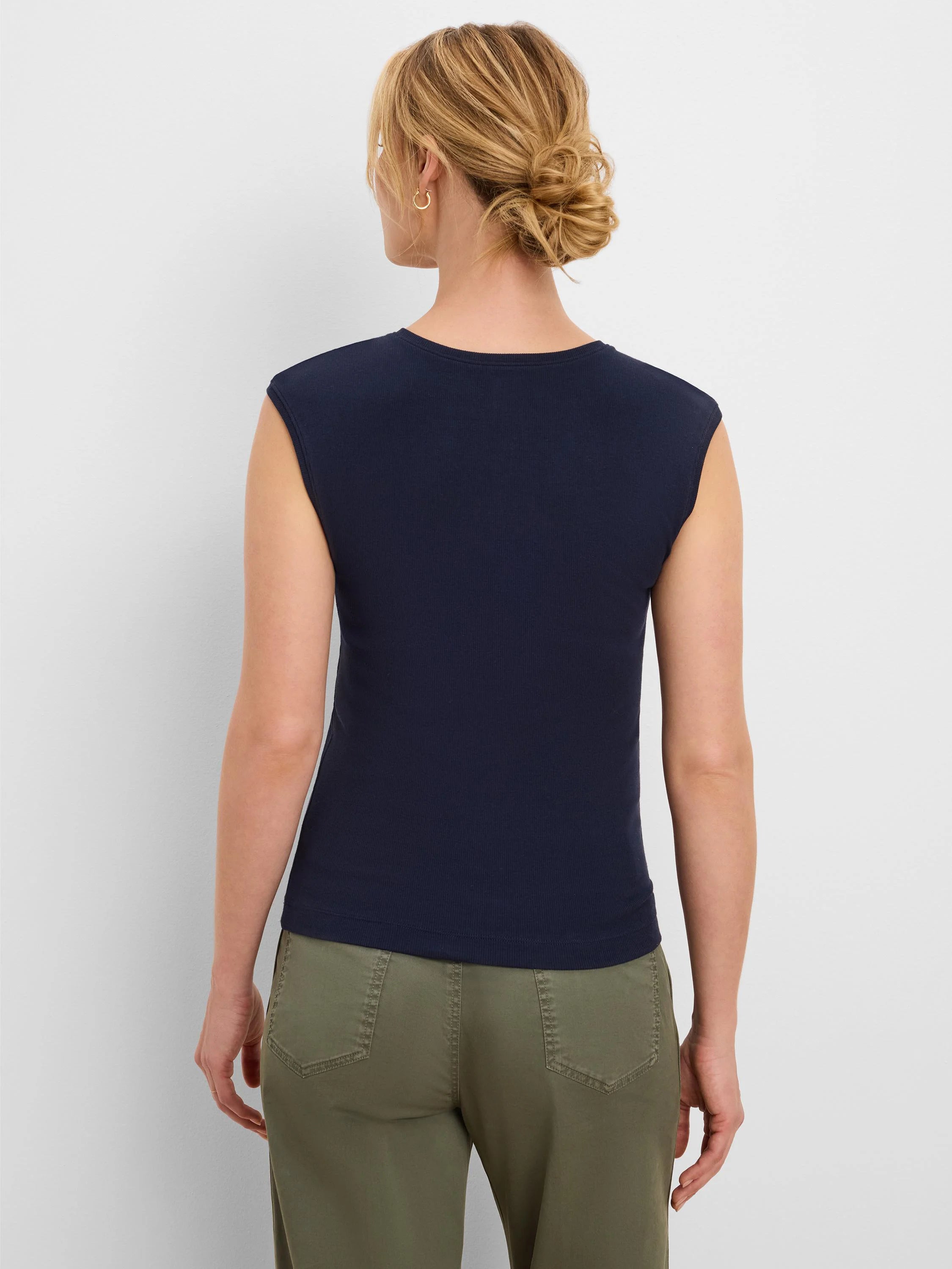 Back view of a woman wearing a navy blue, ribbed, sleeveless tank top with a round neck.